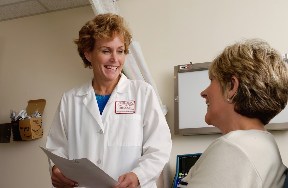 A clinician going through paperwork with a patient in an exam room.